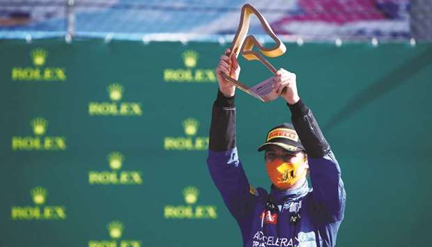 McLarenu2019s Lando Norris celebrates with the trophy on the podium after finishing third at the Austrian Grand Prix in Spielberg, Austria, on July 5, 2020. (Reuters)