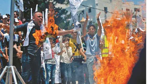 Palestinian supporters burn effigies (unseen) depicting US President Donald Trump, and Israeli Prime Minister Benjamin Netanyahu, during a demonstration against Israelu2019s plans to annex parts of the occupied West Bank, in Rafah in the southern Gaza Strip, yesterday.