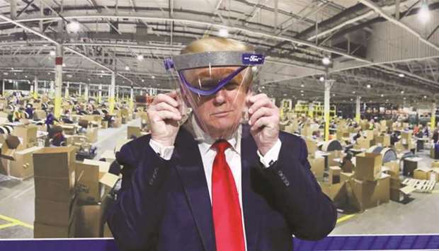 Trump holds up a protective face shield during a behind-the-scenes tour of a Ford facility in Michigan in May.