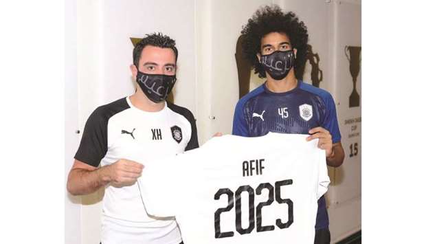Al Sadd forward Akram Afif (right) poses with head coach Xavi after signing a new contract yesterday.