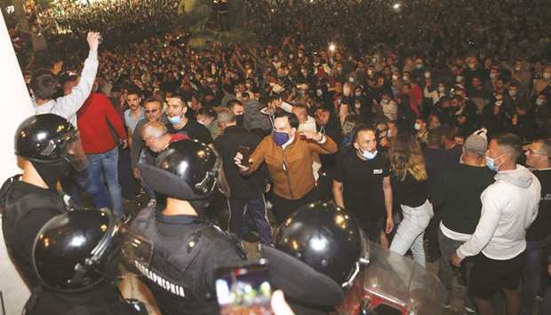 Protesters shout slogans in front of the National Assembly building in Belgrade on Tuesday night.