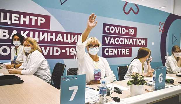 A healthcare worker waves to invite next in line to get a dose of Russiau2019s Sputnik V or Sputnik Lite Covid-19 vaccine, at a vaccination centre at the Olympic Luzhniki football stadium in Moscow.