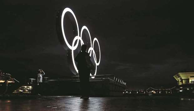 Visitors take a photo in front of a newly installed Olympic rings in Yokohama, Japan.