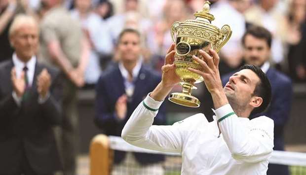 Serbiau2019s Novak Djokovic celebrates with the trophy after winning Wimbledon in London yesterday. (Reuters)