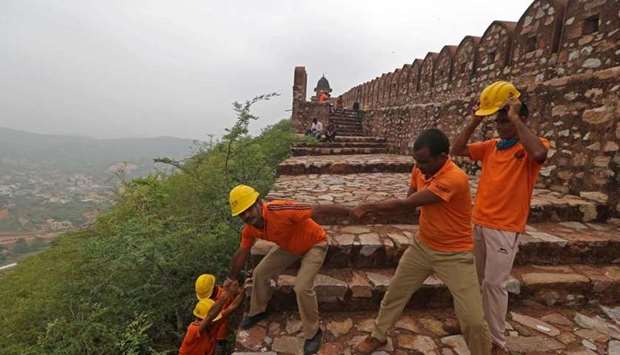Members of State Disaster Response Force conduct a search operation near the watchtowers of the Amer Fort on the outskirts of Jaipur, after 11 people were killed in lightning strikes at the fort.