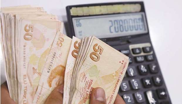 A money changer counts Turkish lira banknotes at a currency exchange office in Diyarbakir, Turkey (file). Turkey targets 5% inflation and the central bank forecasts 12.2% by year end, lower than most analysts.