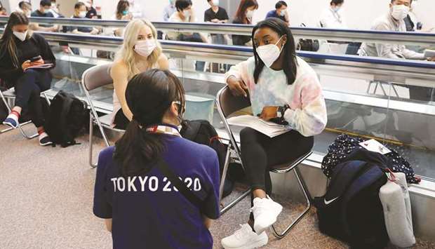 Members of the US gymnastics team, including Simone Biles (right), talk with a Tokyo 2020 Olympic Games official as they wait to take the coronavirus antigen test after arriving at Narita International Airport, east of Tokyo, yesterday. (Reuters)