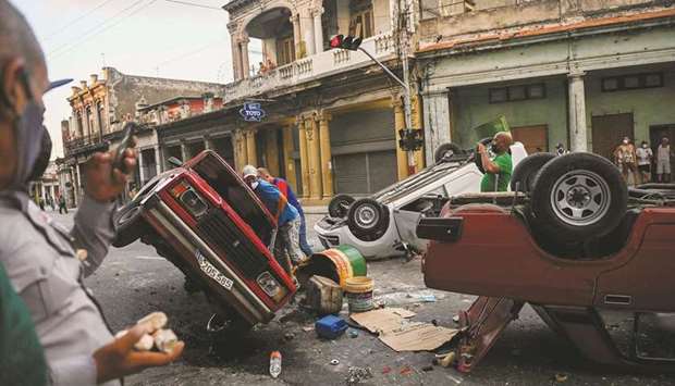 Police cars are seen overturned during a demonstration against Cuban President Miguel Diaz-Canel in Havana.