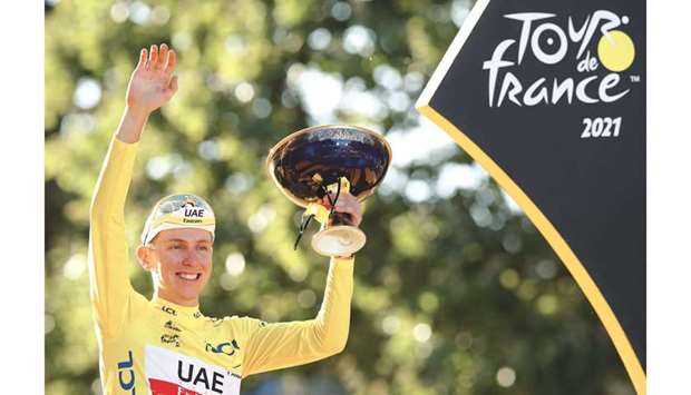 UAE Team Emirates rider Tadej Pogacar of Slovenia celebrates on the podium after winning the yellow jersey and the Tour de France title in Paris yesterday. (Reuters)