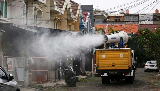 Indonesian Red Cross personnel spray disinfectant using a gunner at a residential area around the Daan Mogot neighborhood, as the coronavirus disease (Covid-19) cases surge in Jakarta, Indonesia