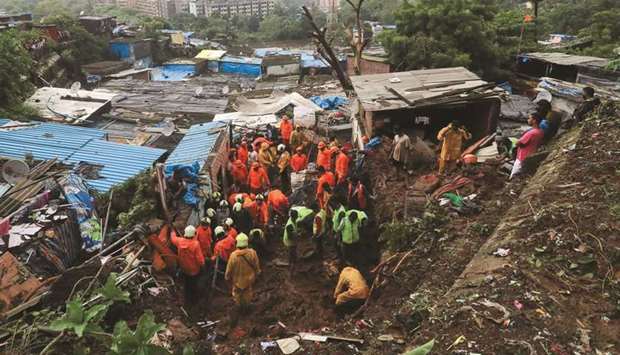 Rescue workers search for survivors after a residential house collapsed due to landslide caused by heavy rainfall in Mumbai, India, yesterday.