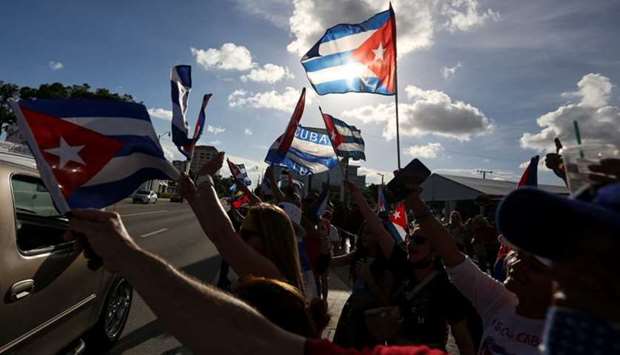 Emigres react to reports of protests in Cuba against its deteriorating economy, in Miami, Florida Emigres wave Cuban flags outside Versailles restaurant, in reaction to reports of protests in Cuba against its deteriorating economy, in Miami, Florida, US