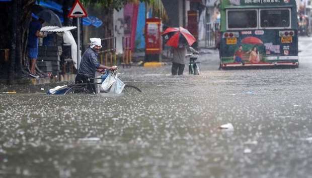 People wade through a waterlogged road after heavy rainfall in Mumbai, India, July 16.
