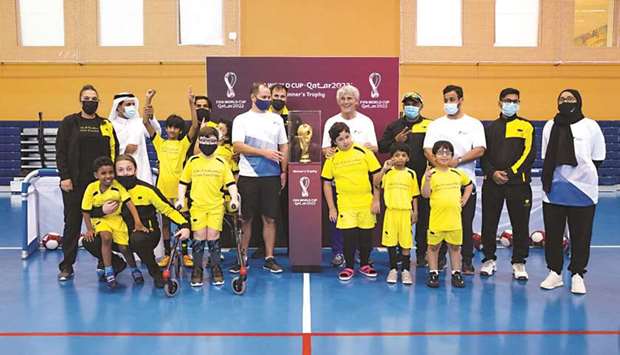 Children from the Generation Amazing u2013 Qatar Foundation Ability Friendly Programme pose with the FIFA World Cup trophy at Qatar Foundationu2019s Multaqa (Education City Student Centre).