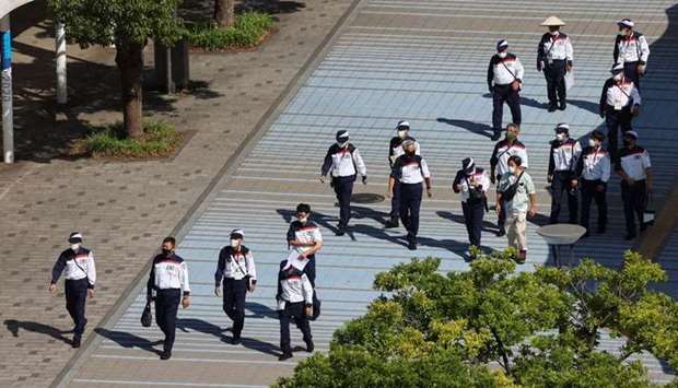 Tokyo 2020 Olympic Games security personnel walk near the Main Press Center as the coronavirus disease continues in Tokyo. REUTERS