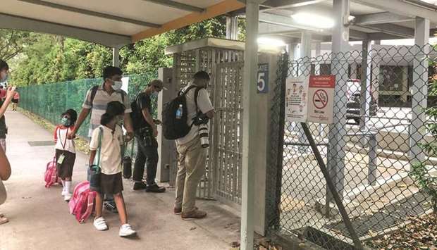 People pick up students leaving River Valley High School in Singapore yesterday.