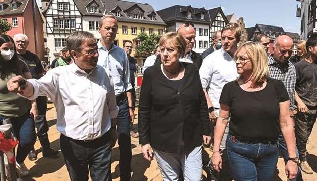 German Chancellor Angela Merkel and North-Rhine Westphalia State Premier Armin Laschet walk with Bad Muenstereifel Mayor Sabine Preiser-Marian through the flood-ravaged Bad Muenstereifel, yesterday.