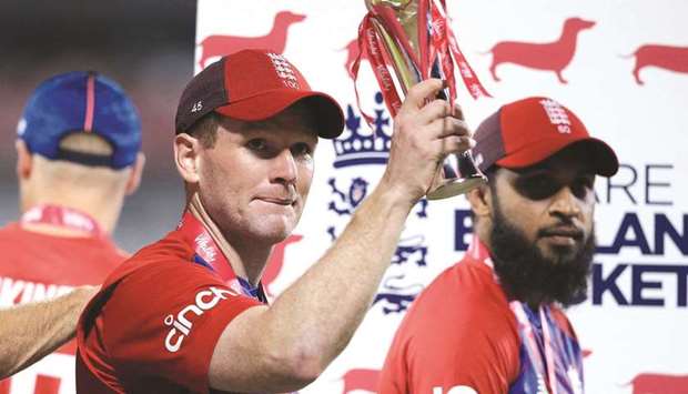 Englandu2019s Captain Eoin Morgan raises the winneru2019s trophy as Adil Rashid (right) looks on following their win in the third T20I against Pakistan at Old Trafford Cricket Ground in Manchester, England. (AFP)