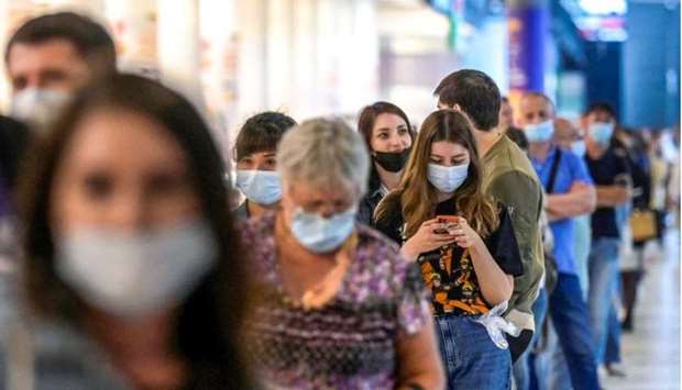 People wearing protective face masks queue for their vaccination at a shopping mall in Moscow.