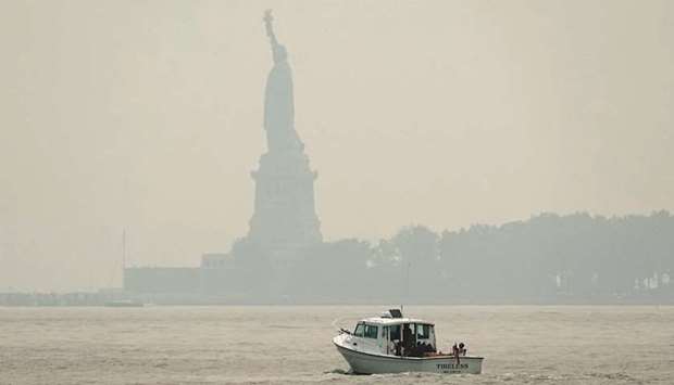 The hazy Statue of Liberty is seen from Exchange Place in Jersey City, New Jersey, as New York officials issue an air quality health advisory due to the west coast wildfires.