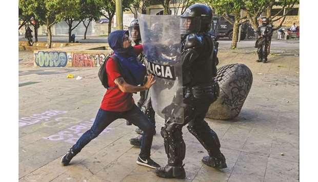 A protester clashes with a riot police officer during a rally yesterday against the government of Colombian President Ivan Duque in Medellin, Colombia.