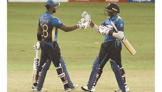 Sri Lankau2019s Avishka Fernando (left) celebrates after scoring half-century with teammate Bhanuka Rajapaksa during the third ODI against India at the R. Premadasa Stadium in Colombo yesterday. (AFP)