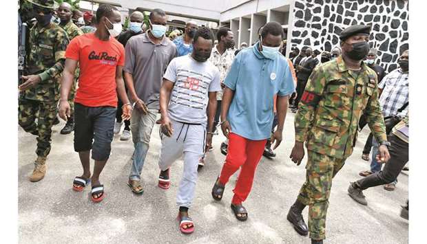 Armed Nigerian naval officers lead pirates away from a courtroom at The Federal High Court in Lagos, yesterday, after being convicted for hijacking a Chinese fishing vessel with 18 crew members on board in 2020.