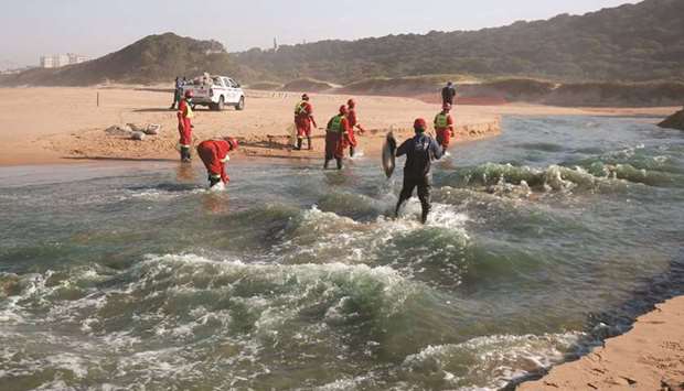 File photo shows members of a hazardous waste cleanup crew collect dead fish, after chemicals entered the water system from a warehouse which was burned during days of looting following the imprisonment of former South African president Jacob Zuma, in Durban.