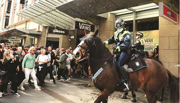 Protesters throw plastic bottles and pot plants at mounted police in Sydney.