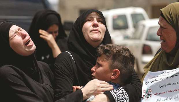 Relatives and the mother of Palestinian Mohamed al-Tamimi, who was killed by Israeli forces during a clash on Friday, according to officials, mourn during his funeral in Deir Nidham in the occupied West Bank, yesterday.