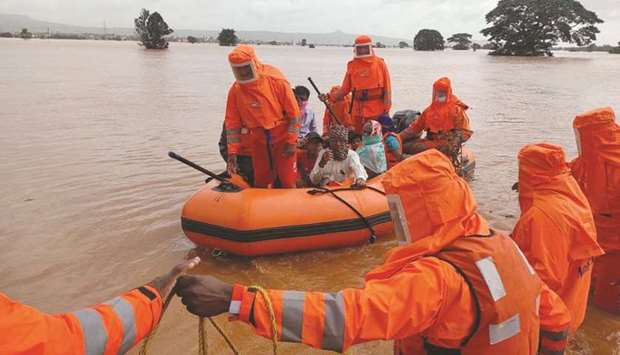 Members of National Disaster Response Force (NDRF) evacuate people from a flooded area to safer places in Balinge village, Kolhapur district, in the western Indian state of Maharashtra, India, yesterday.