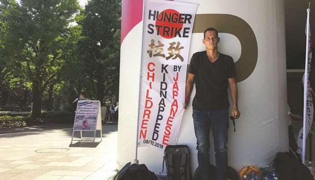 French father-of-two Vincent Fichot stands next to a banner where he has been on a hunger strike since July 10 to protest what he says is Japanu2019s sanctioning of child u2018abductionsu2019 by a parent, near the Olympic Stadium in Tokyo, Japan.