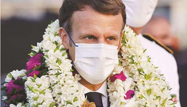 French President Emmanuel Macron covered in garlands during a welcoming ceremony upon his arrival at Faau2019a international airport for a visit to Tahiti. (AFP)