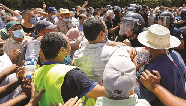 A police officer pushes back supporters of Tunisiau2019s biggest political party, the moderate Islamist Ennahda, as they attempt to reach the parliament building in Tunis on Monday. Hard-currency bonds issued by Tunisiau2019s central bank dropped by record amounts on Monday after the dismissal of the government by the countryu2019s president left it facing its biggest crisis in a decade of democracy.