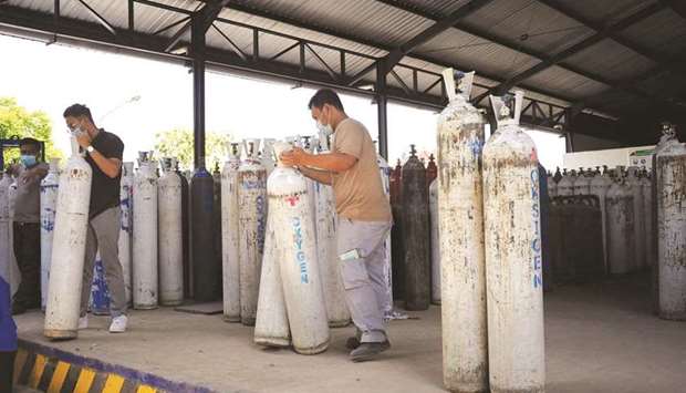 Workers handle oxygen cylinders at the Samabayu Mandala (Samator) distribution centre in Mengwi.