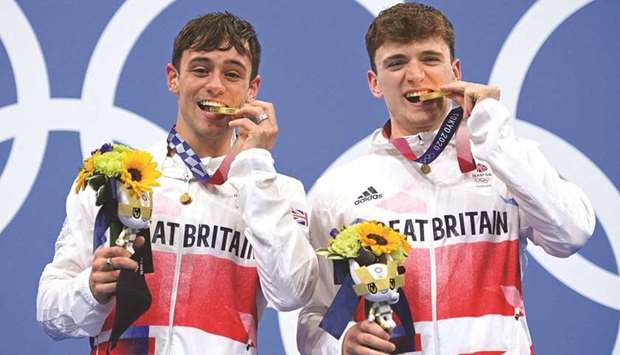 Britainu2019s Thomas Daley (left) and Matty Lee poses with their gold medals after wining the menu2019s synchronised 10m platform diving during the Tokyo 2020 Olympic Games at the Tokyo Aquatics Centre in Tokyo yesterday. (AFP)