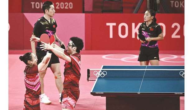 Japanu2019s Mima Ito (left) and Jun Mizutani celebrate after beating Chinau2019s Xu Xin (second left) and Liu Shiwen (right) to win the mixed doubles table tennis final in Tokyo yesterday. (AFP)