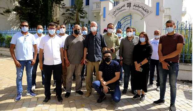 Al Jazeera bureau chief Lotfi Hajji (centre) and his team pose for a picture outside  the National Syndicat (SNJT) headquarters in Tunis, yesterday.