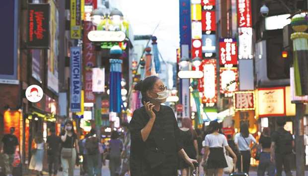 A woman wearing a protective mask amid the coronavirus disease outbreak, makes her way in Tokyo yesterday. The Washington-based crisis lender once again stressed that u201cthe immediate priority is to deploy vaccines equitably worldwide.u201d