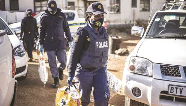 South African police officers recover items at the Nguni Hostels in Vosloorus, yesterday, during a joint operation between the South Africa Police Service (SAPS) and the South Africa National Defence Forces (SANDF).