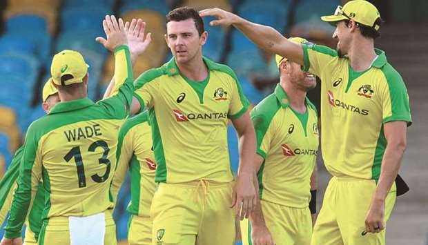 Australiau2019s Josh Hazlewood (second left) and Mitchell Starc (right) celebrate the dismissal of West Indiesu2019s Alzarri Joseph (not pictured) during the third and final ODI at Kensington Oval, Bridgetown, Barbados. (AFP)