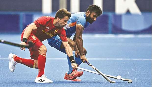 Spainu2019s Marc Salles (left) and Indiau2019s Surender Kumar vie for the ball during their Tokyo Olympic Games Pool A hockey match yesterday. (AFP)