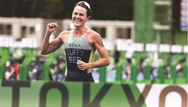 Bermudau2019s Flora Duffy gestures as she crosses the finish line of the womenu2019s individual triathlon competition during the Tokyo 2020 Olympic Games at the Odaiba Marine Park yesterday. (AFP)