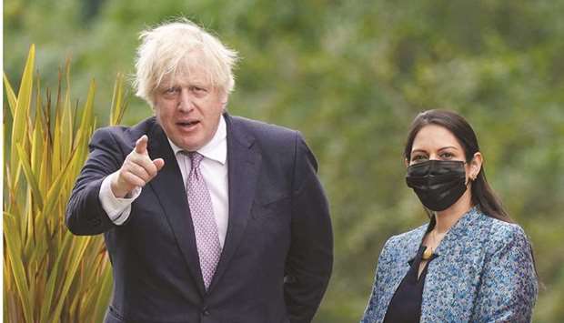 Britainu2019s Prime Minister Boris Johnson gestures with Home Secretary Priti Patel standing by his side during a visit to Surrey Police headquarters to coincide with the publication of the governmentu2019s Beating Crime Plan in Guildford, Surrey, Britain, yesterday.
