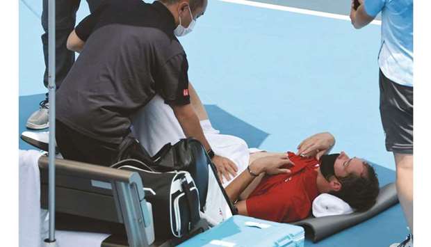 Russiau2019s Daniil Medvedev is assisted by a physio during Tokyo 2020 Olympic Games menu2019s singles third round match against Italyu2019s Fabio Fognini at the Ariake Tennis Park in Tokyo yesterday. (AFP)
