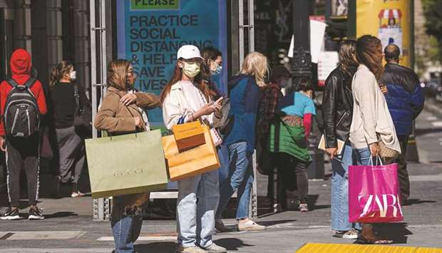 People wearing protective masks carry shopping bags while waiting to cross Geary Street in San Francisco. US consumer spending rose more than expected in June as vaccinations against Covid-19 boosted demand for travel-related services, but part of the increase reflected higher prices, with annual inflation accelerating further above the Federal Reserveu2019s 2% target.