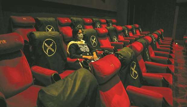 A woman watches a movie at a multiplex after cinema theatres reopened with 50% occupancy as the coronavirus imposed lockdown eases further, in New Delhi, yesterday.
