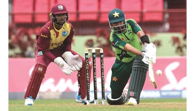 Babar Azam of Pakistan plays a shot as West Indiesu2019 Nicholas Pooran looks on during the 3rd T20I at Guyana National Stadium in Providence, Guyana, yesterday. (AFP)