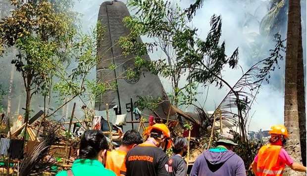 Rescue workers arrive as smoke billows from the wreckage of a Philippine Airforce C-130 transport plane after it crashed near the airport in Jolo town, Sulu province on the southern island of Mindanao. AFP/ JOINT TASK FORCE-SULU (JTF-SULU)
