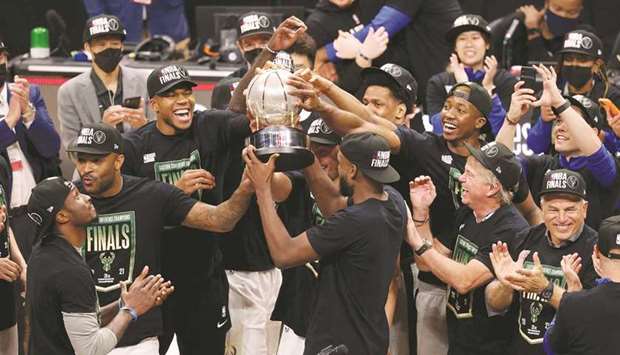 Milwaukee Bucks forward Khris Middleton holds up the Eastern Conference Finals Trophy and celebrates with teammates after the Bucks defeated the Atlanta Hawks in game six of the Eastern Conference Finals for the 2021 NBA Playoffs in Atlanta. (USA TODAY Sports)